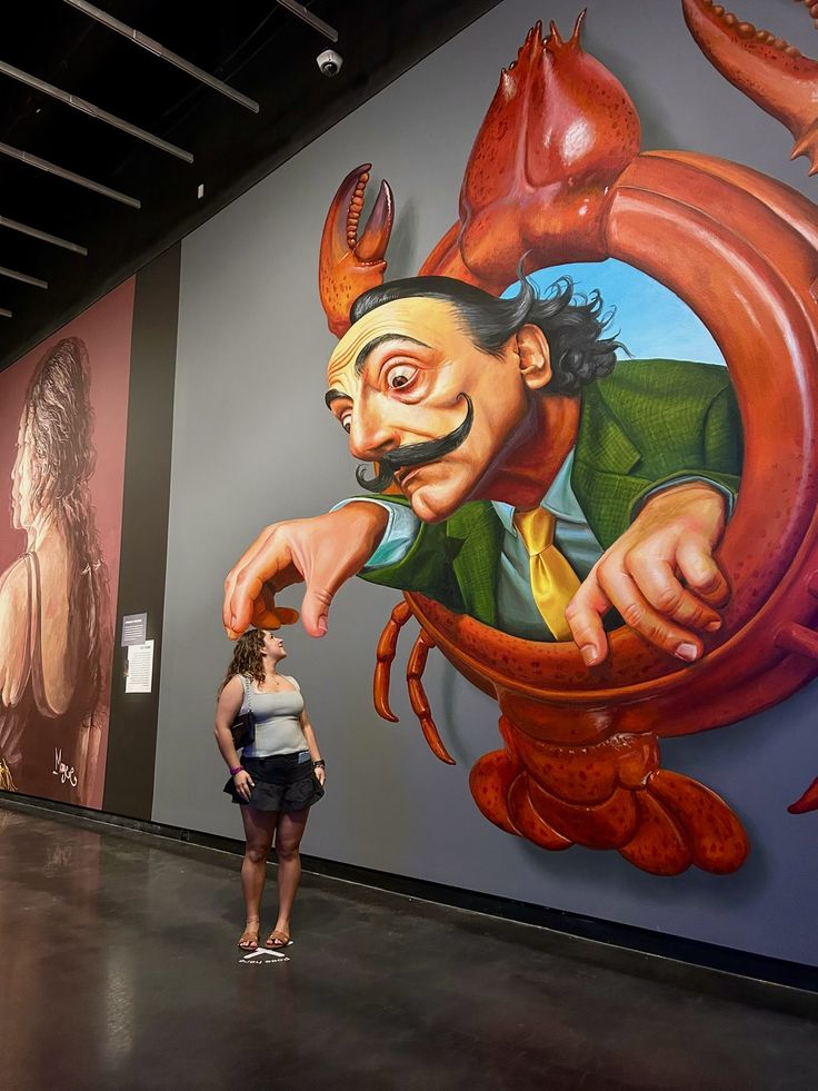 Artist posing in front of a finished wall mural